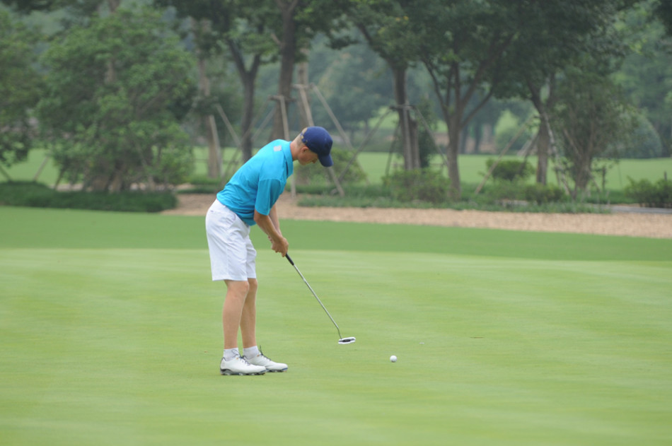 沙坑中的精湛救球：高尔夫球手在沙坑中挥杆，沙砾飞扬，动作潇洒有力，展现出面对困境时娴熟的技术与专注。