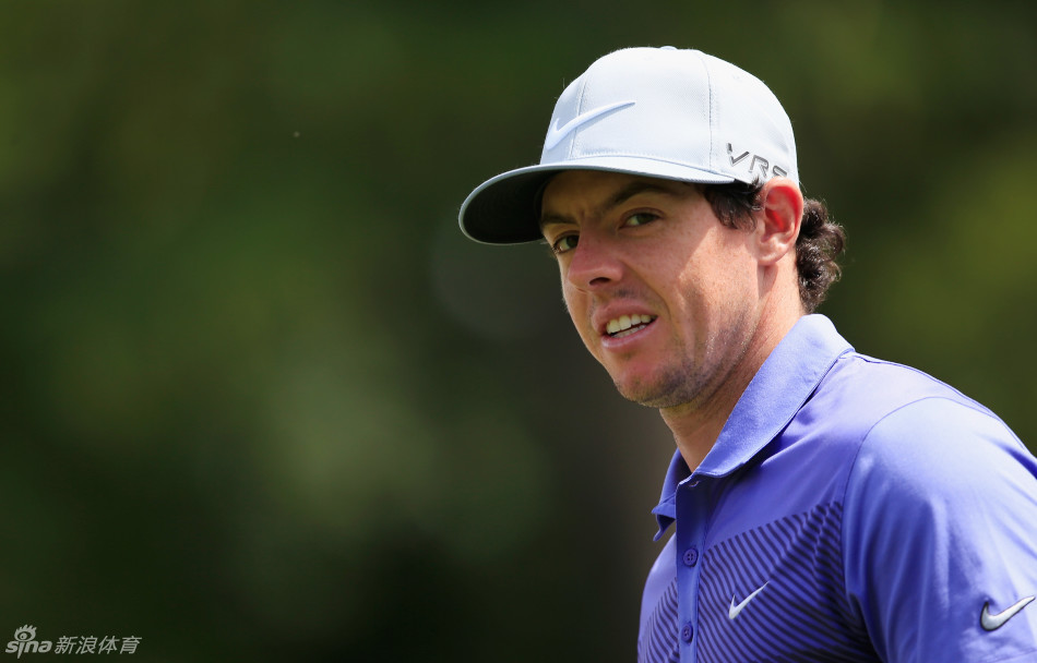 麦克罗伊与球童并肩站在球道上，两人目光坚定，专注地商讨下一杆的策略。