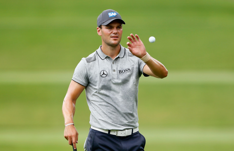 德国球星马丁·凯梅尔正专注于比赛，他沉着地从球童手中接过高尔夫球，准备下一杆的挑战。