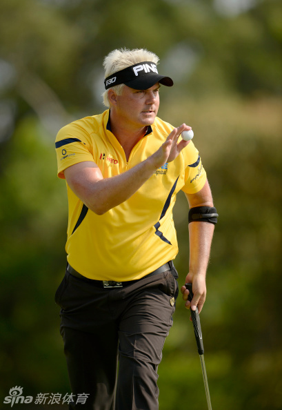 一名选手在完美修整的球道上挥杆，身体扭转充满力度，白色小球在蓝天背景下划出优美弧线。