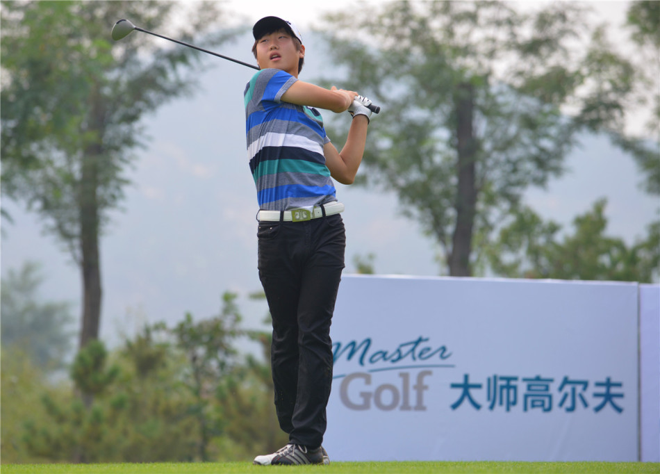 两位高尔夫球手与球童一同在果岭边弯腰观察地形，共同商讨推杆的线路与策略