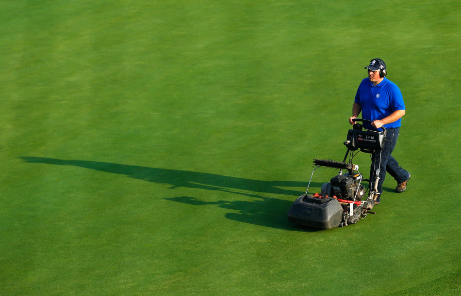球道两侧，极具视觉冲击力的金色莱德杯奖杯模型与深色赛事标识并肩而立，共同凝视着球场，象征着至高荣誉的召唤。
