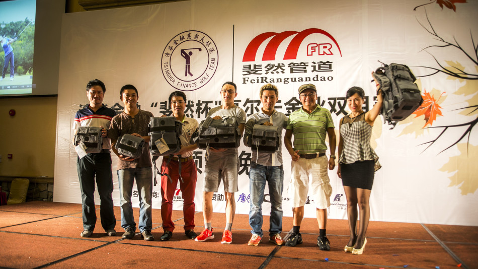 颁奖嘉宾正将一座闪亮的奖杯递给获奖者，周围人群纷纷鼓掌，现场充满喜悦与祝贺之情。