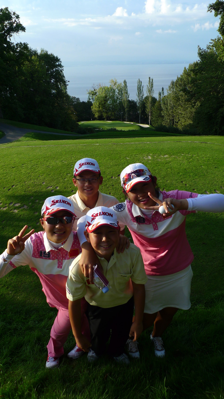 两位中国女将漫步在依云锦标赛的绿茵场上，背影融入湖光山色之中，象征着她们走向世界舞台的从容步伐。