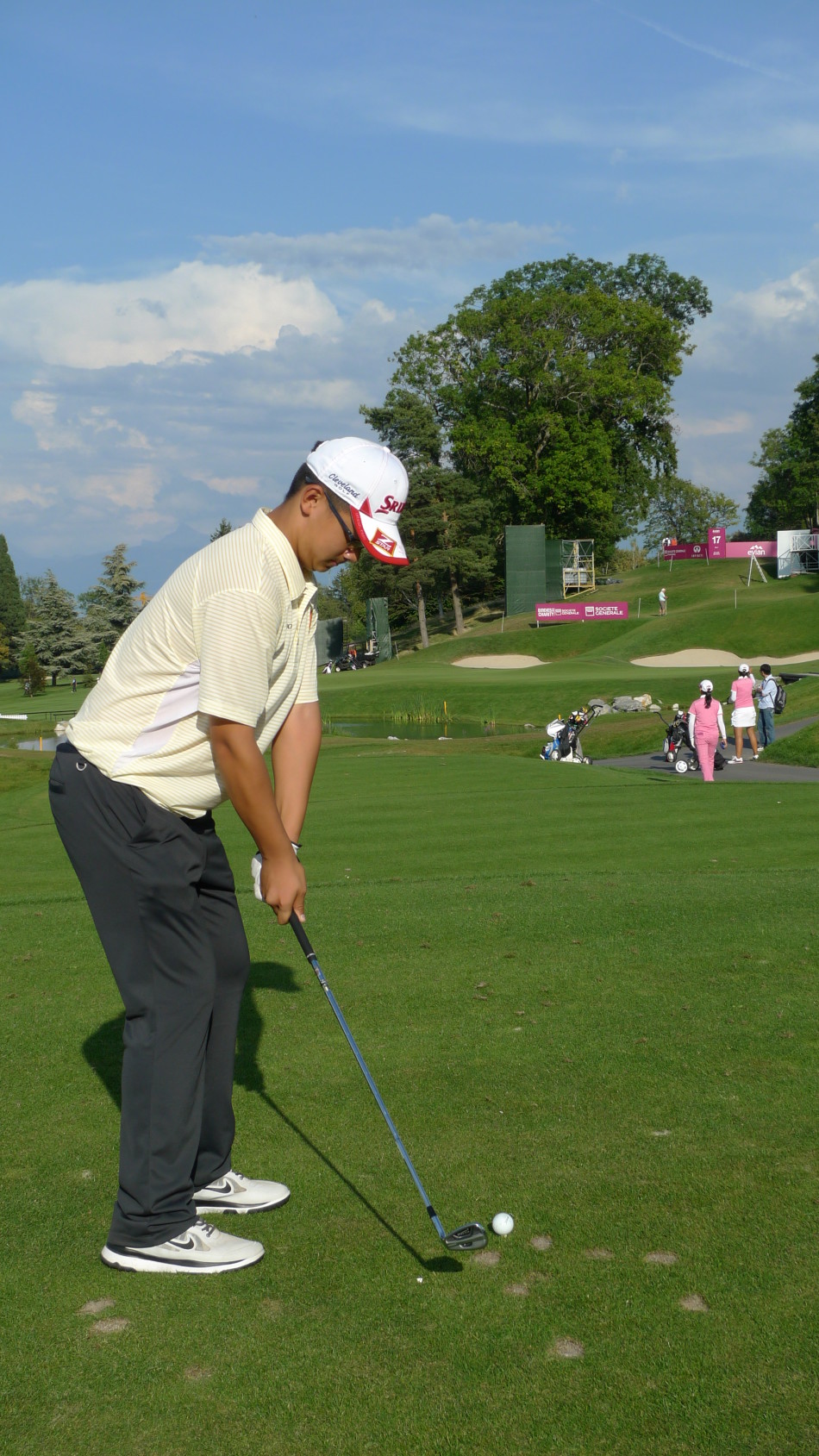 刘文博在球道上全力挥杆，阳光洒在她的身影上，充满动感与力量，展现新生代球员的锋芒。