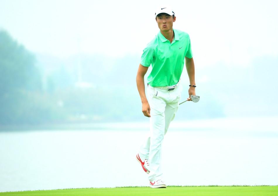 詹世昌在发球台全力开球，身体充分扭转，球杆划过空中，力量与技巧完美结合。