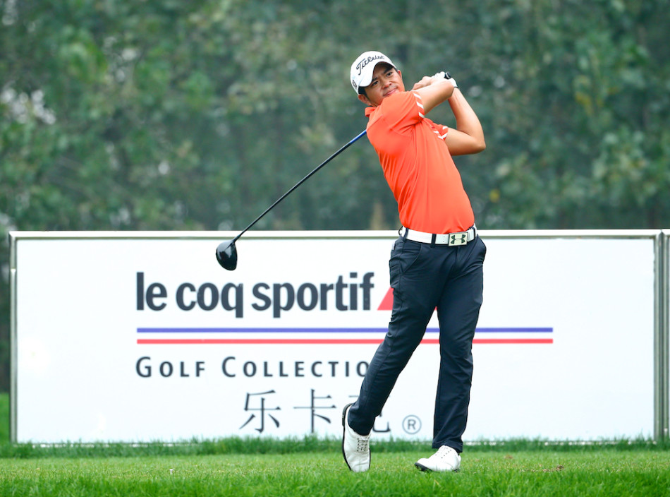 金诚在果岭上屈膝观察，全神贯注地研判草纹与坡度，寻找小球进洞的最佳路径。