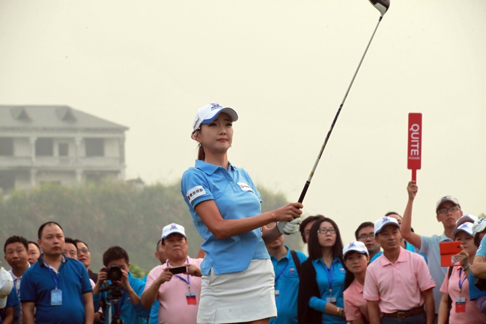 金旲涉完成切杆后优雅收杆,目光紧随小白球飞向漂浮在碧波之上的目标果岭