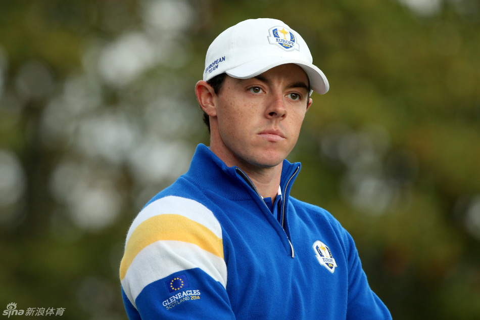 麦克罗伊站在果岭边，双手叉腰，眼神锐利地审视推杆线路，仿佛在计算一场战役。