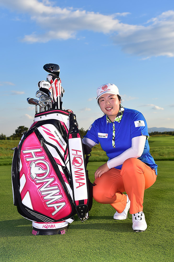 冯珊珊微笑着轻抚自己的HONMA球具，眼神中流露出对装备的信任与珍爱