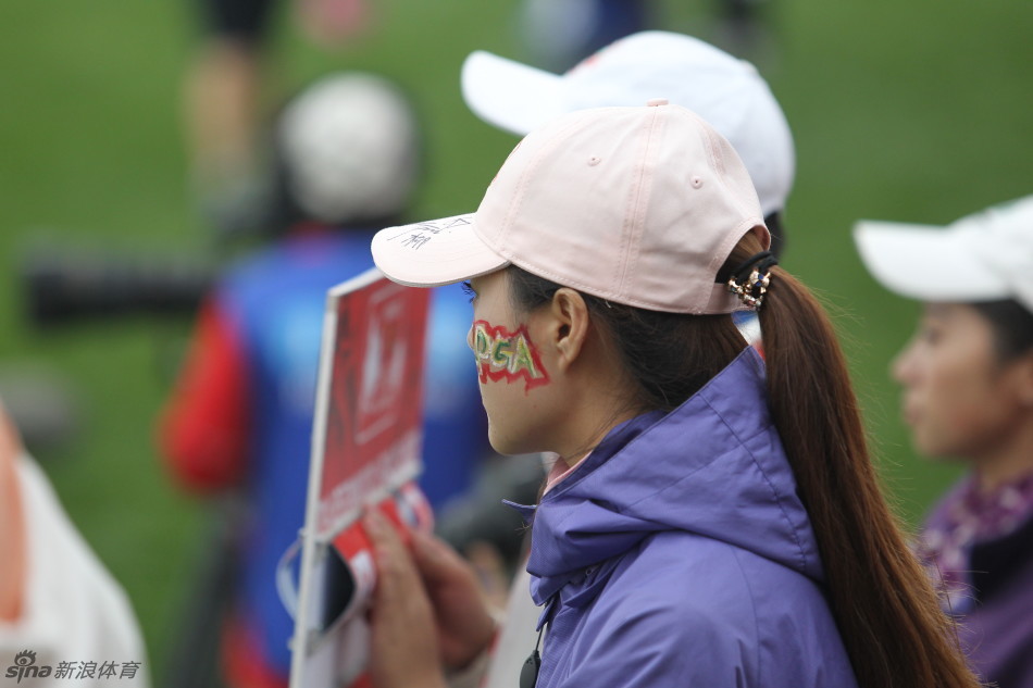 一位观众正在请彩绘师在其手背上绘制精美的图案，神情专注而充满期待