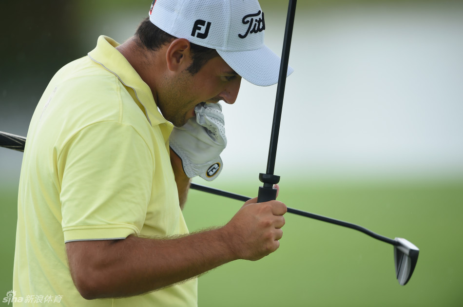 南非选手托马斯·艾肯在球道上行走，阳光穿透云层洒下，球童紧随其后，构成一幅和谐的竞赛画卷。