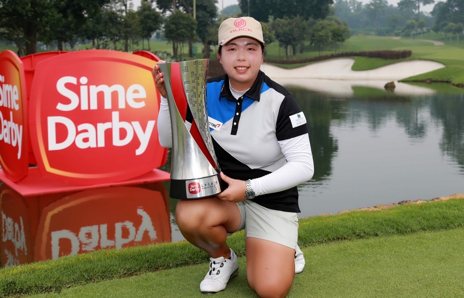 冯珊珊双手高高举起冠军奖杯，脸上洋溢着无比自豪的灿烂笑容