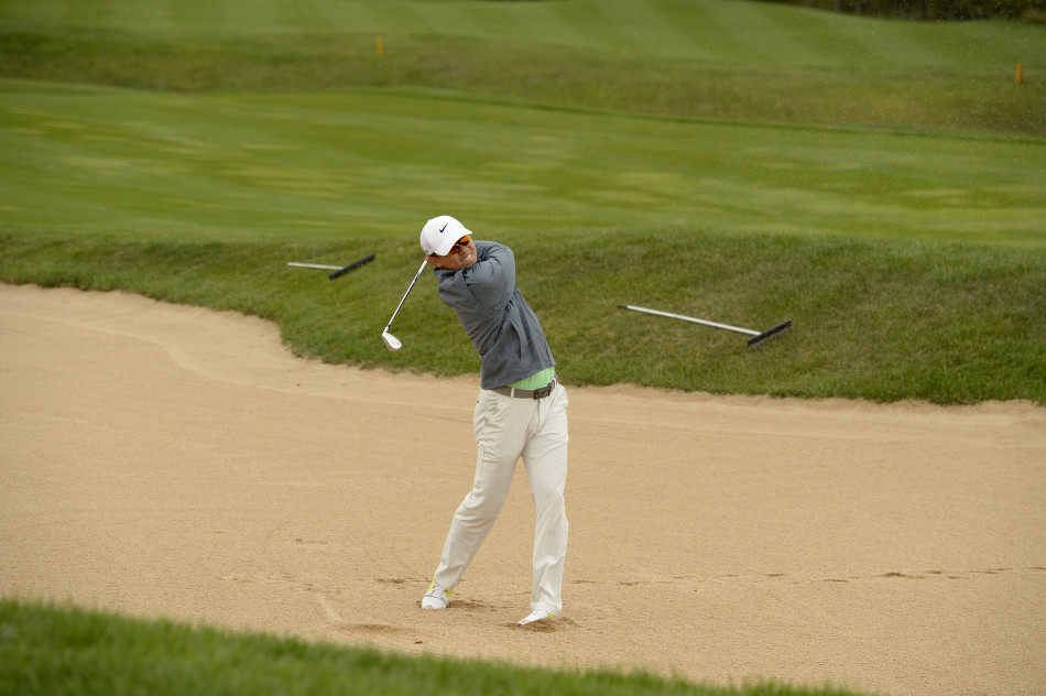 李昊桐在果岭边全神贯注准备击球，眼神锐利如鹰，周围观众屏息以待