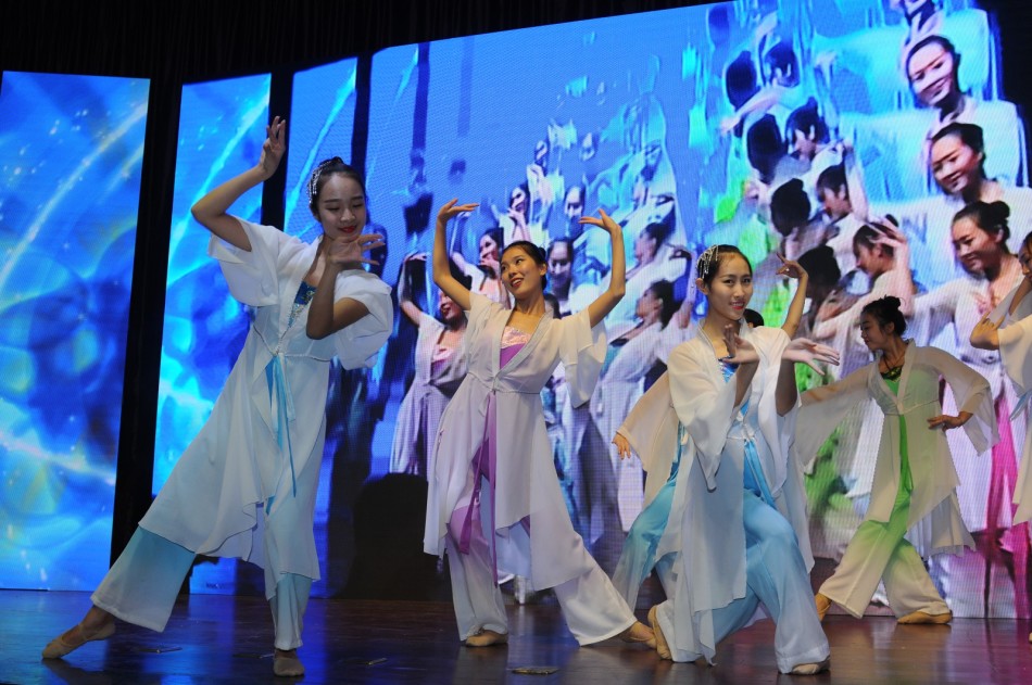 舞者身着青蓝色长裙，在舞台中央优雅旋转，中国风舞蹈《七秀坊》的裙摆如花朵般绽放。