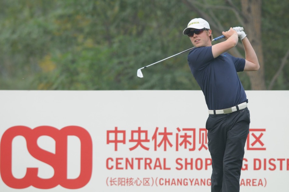 球员在环境优美的长阳核心区球场上准备击球,背景建筑与现代绿茵相映成趣。