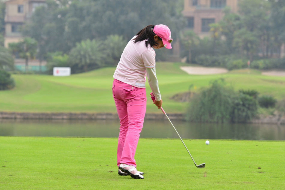 女球员蔡欣儒在球道上全神贯注，正准备进行关键的击球，眼神坚定地望向球道远方