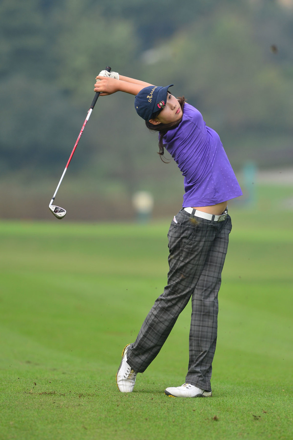 球员龙文武以教科书般的标准姿势收杆，身体重心完全转移，彰显出扎实的训练功底与力量感