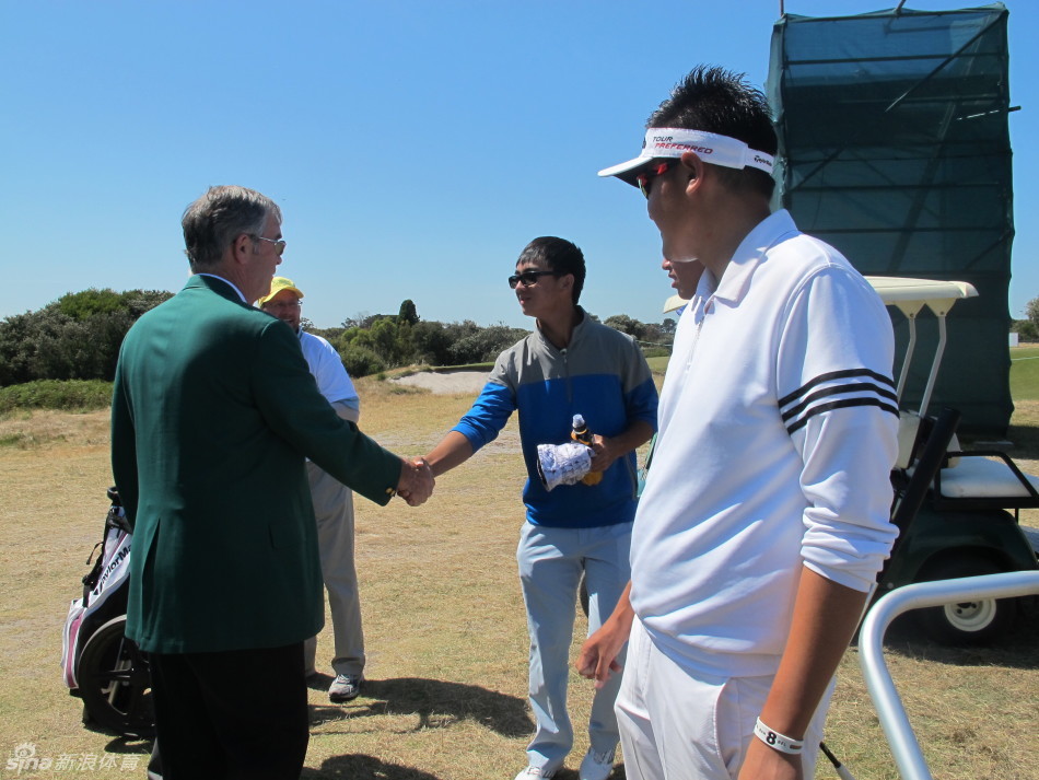 扎克·约翰逊在果岭旁，与几位中国年轻球员们围站在一起，认真观察他们的推杆线路，进行着细致的交流与指导。