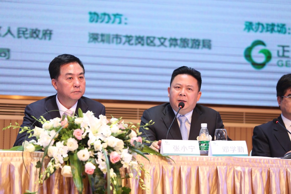 嘉宾在深圳国际赛签到处微笑留影，背景板上赛事标识醒目