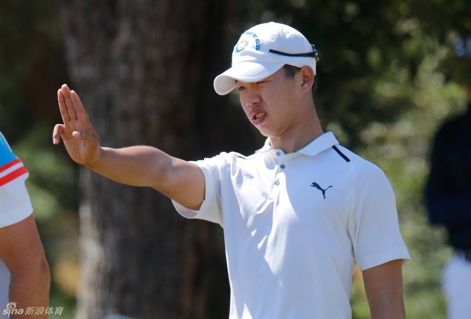 一位不丹选手在沙坑中奋力救球，沙坑边缘的陡坡考验着他的平衡与技巧，这是国际赛场上拼搏精神的缩影