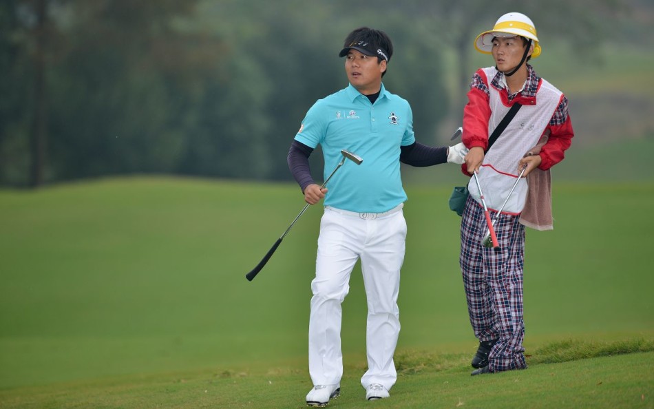 球员俯身仔细察看果岭草纹走向，指尖轻触草地感受坡度