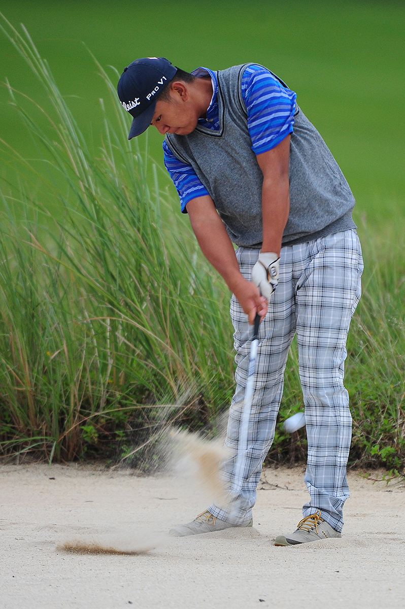 宋依霖在果岭边半蹲，聚精会神地观察推杆线路，眼神锐利如锁定目标的猎鹰。