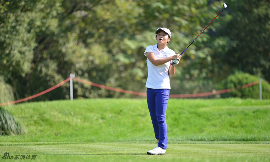 曹怡静俯身于果岭之上,神情无比专注地准备推出关键一杆,她的目光牢牢锁定了不远处的球洞。
