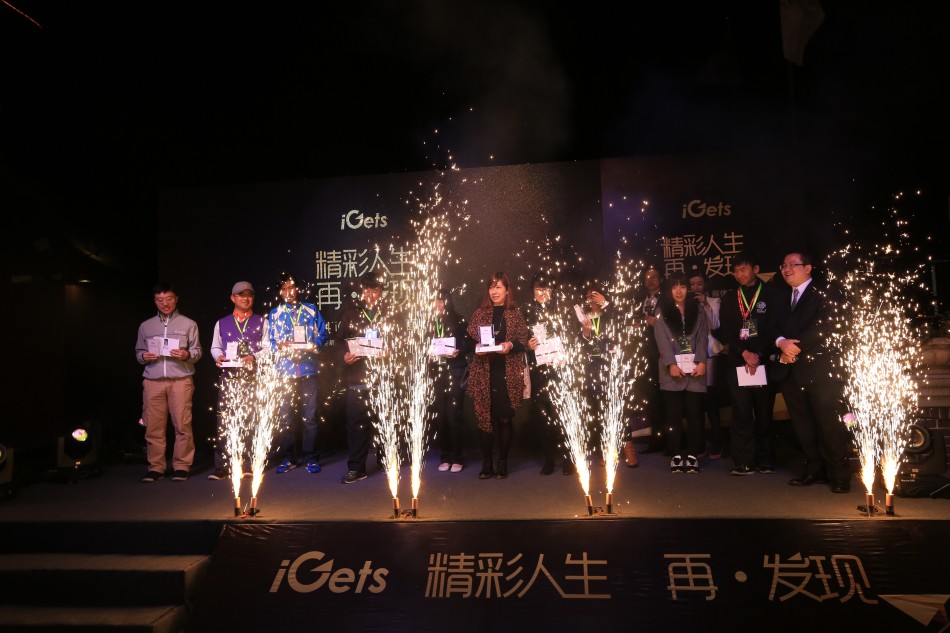 一位优雅的女士手持香槟，在游轮船头自信亮相，她的身后是华灯初上的外滩万国建筑博览群。