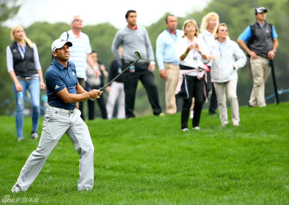 球迷们聚集在赛场周边，聚精会神地观看比赛，脸上写满对高尔夫的热爱