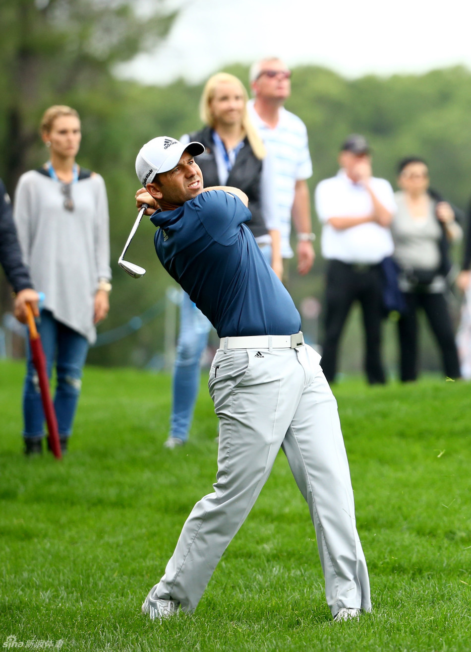 西蒙-戴森在果岭边仔细观察推杆线路，展现职业球员的专业态度