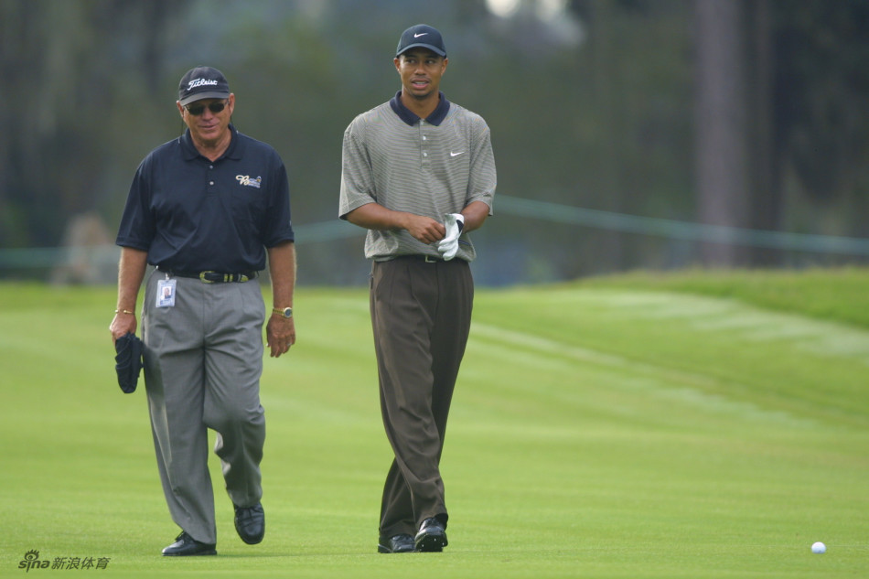 训练间隙，哈蒙正在向伍兹示范某个技术要点，伍兹侧耳倾听，表情轻松而认真。