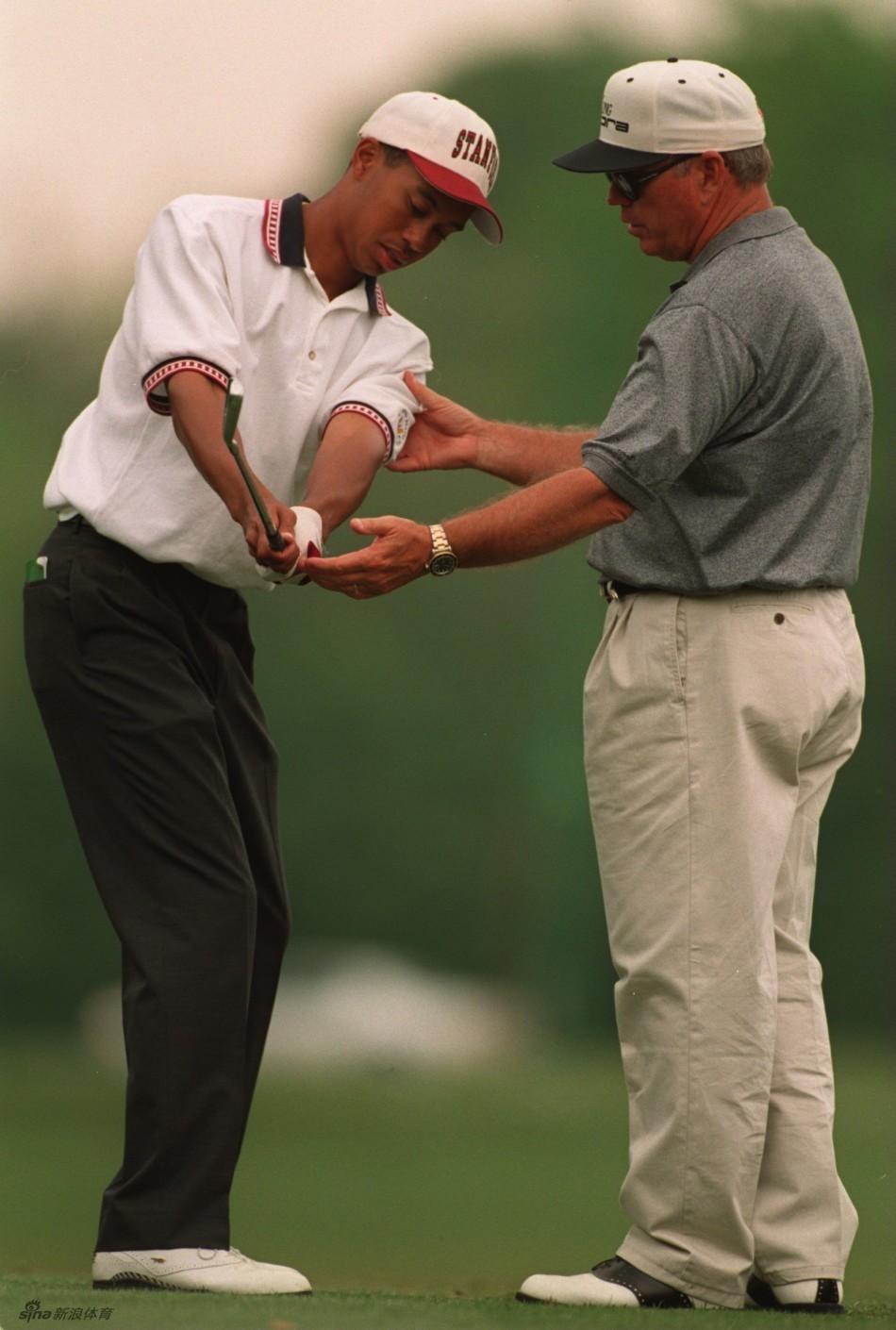 阳光洒在草地上，伍兹完成一次漂亮击球后，与身边的哈蒙相视而笑，气氛融洽愉快。