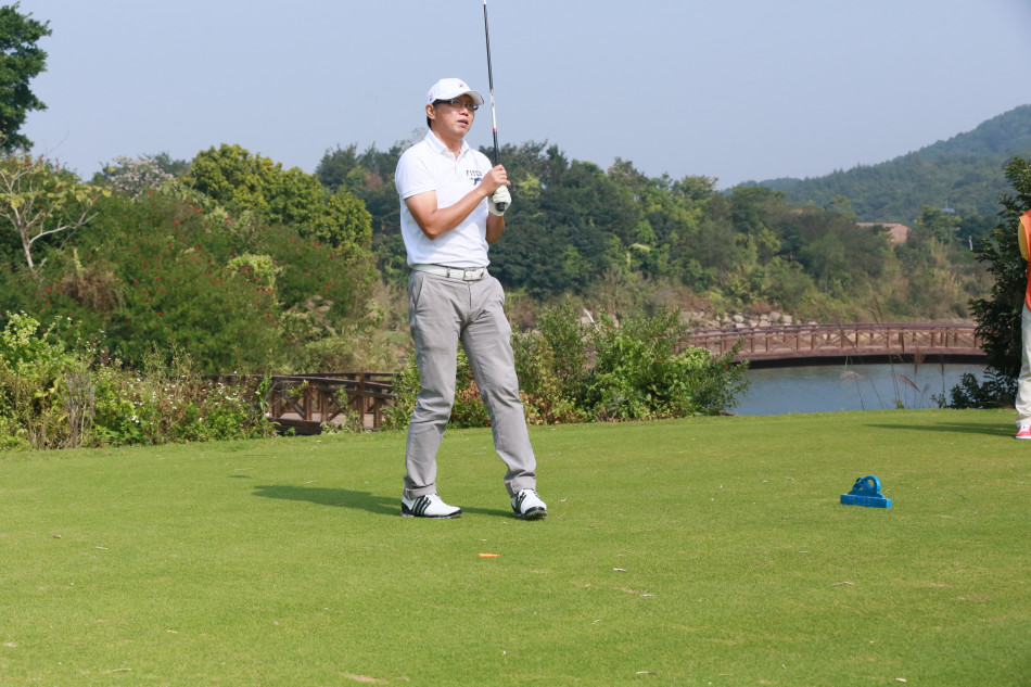 满文军在全神贯注地推杆,身旁球童协助看线,赛场氛围宁静而紧张