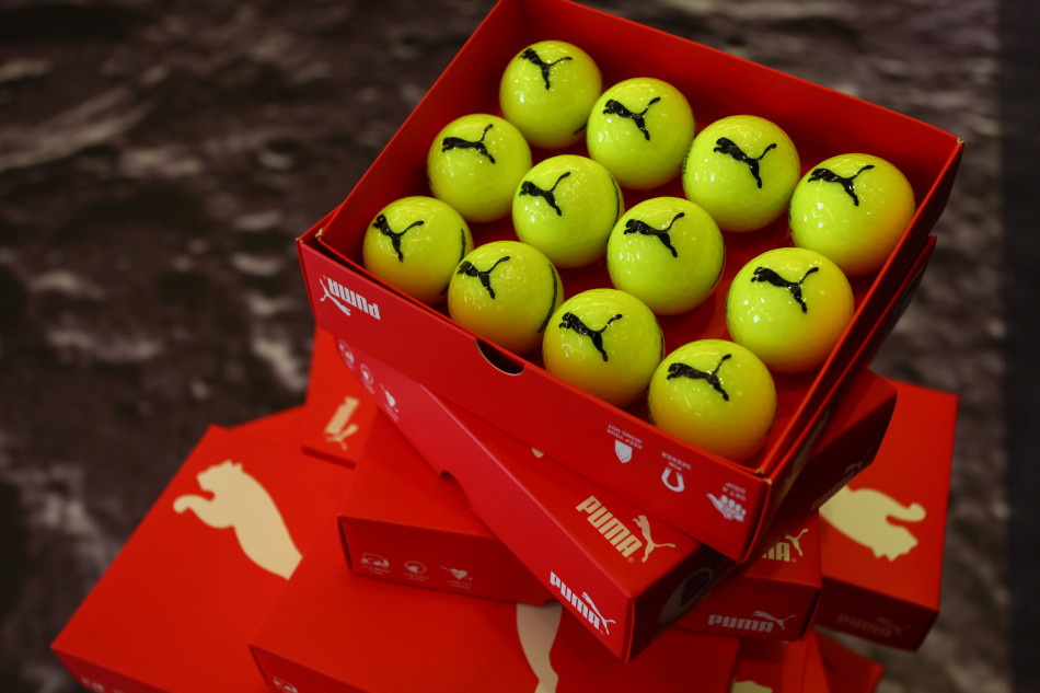 发布会T台全景,模特手持各色球杆自信走秀,背景灯光绚丽,宛如时尚盛会