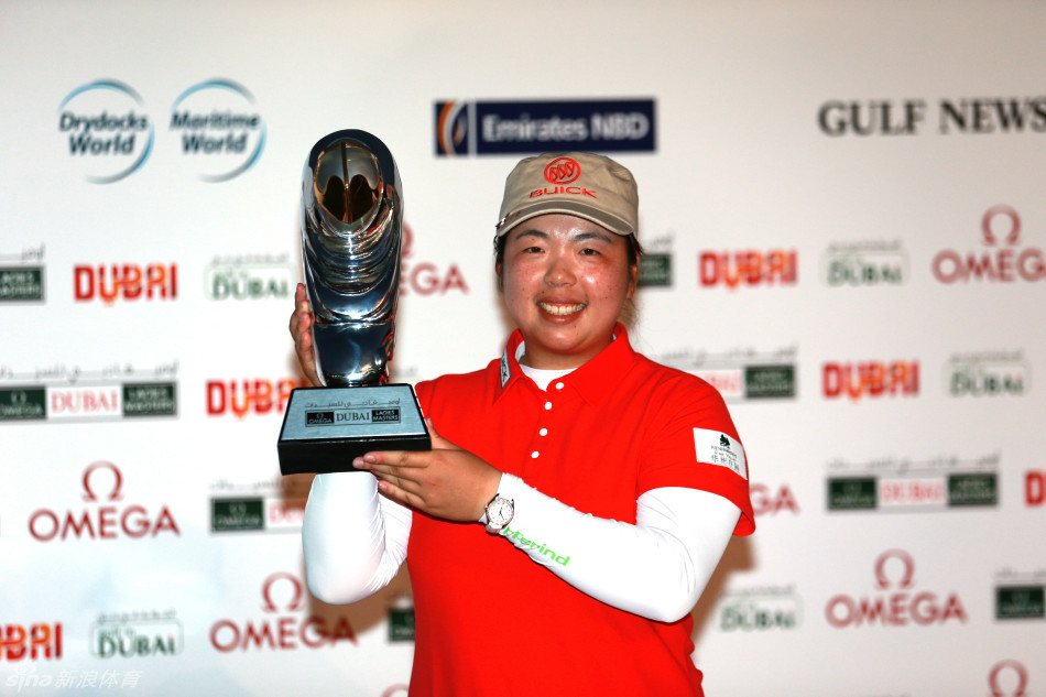 冯珊珊在迪拜的阳光下，高举冠军奖杯，笑容灿烂如花