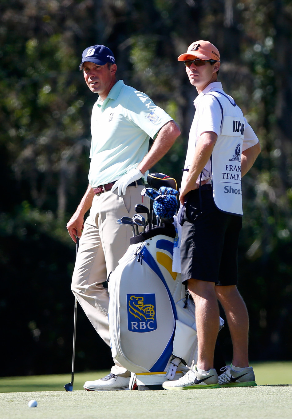 特林加伊在果岭上俯身仔细观察推杆线路，表情专注而沉稳