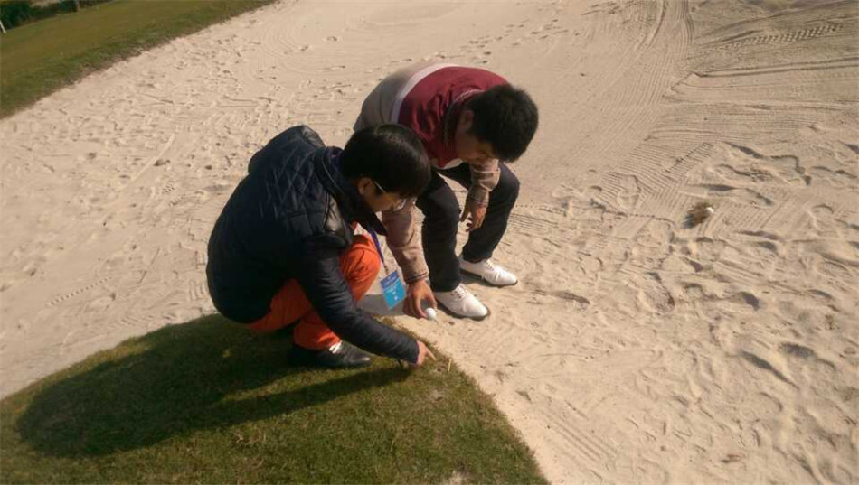 国家级裁判沈子达正专注地为学员演示在果岭上如何准确放置球回原位，每一个步骤都体现着规则的严谨。