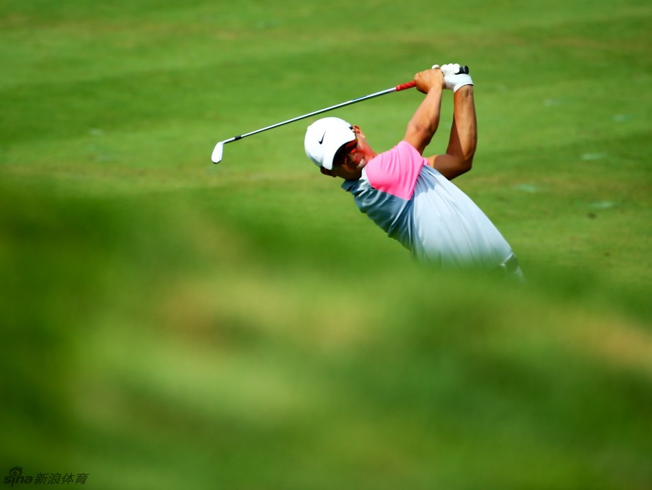 年轻的中国球员李昊桐在长草区中全神贯注地观察球位，他正寻找救球的最佳路线，展现出优秀的临场判断能力。