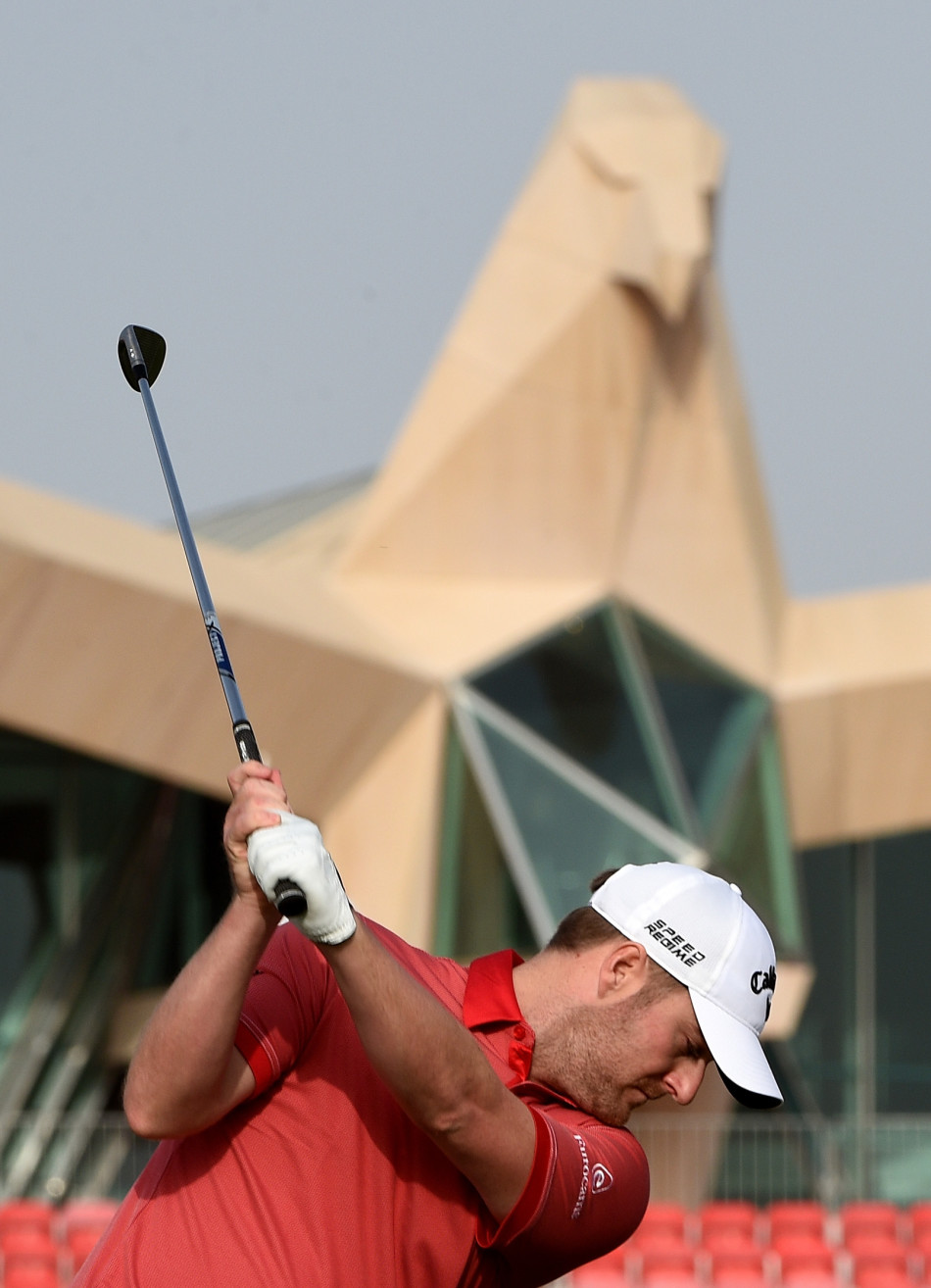 另一位球员马克·沃伦在球道上挥杆击球，阳光下的身影展现出高尔夫运动的力与美。