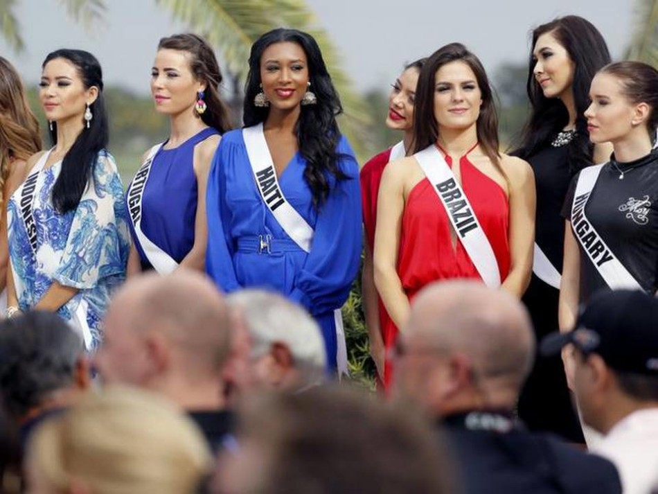 一位非洲小姐佳丽面带灿烂笑容，在高尔夫球场上自信地摆出挥杆后的结束动作，充满活力。