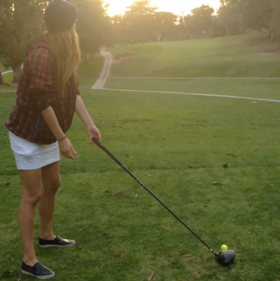 结束一轮练习，妮娜肩扛球杆从容离去，背影在球场的暮色中显得自信而洒脱。