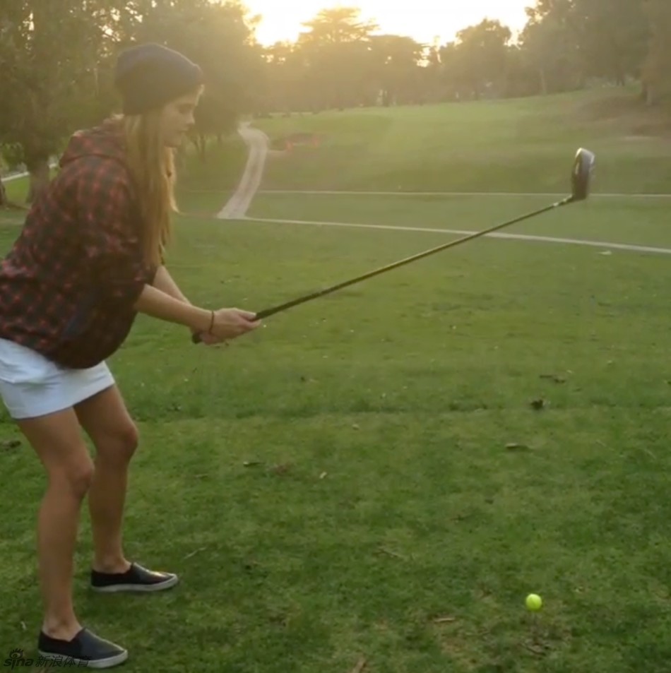 妮娜·阿格戴尔在练习场专注地校准挥杆角度，眼神锐利，姿态充满力量感。