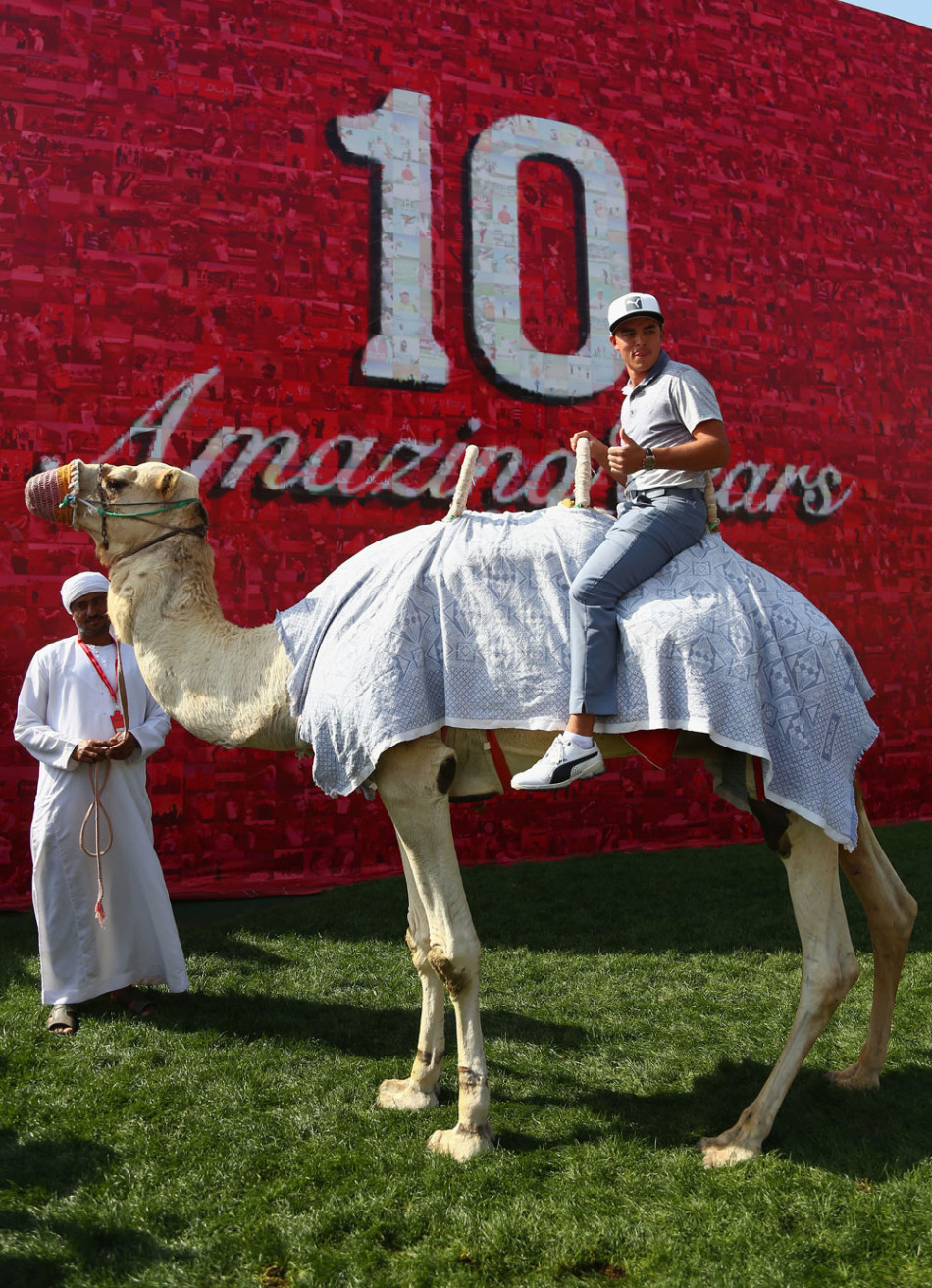 福勒骑在高大的骆驼背上,在球场边的沙地上悠然前行,与周围现代化的球场设施形成有趣对比。