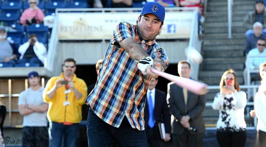 巴巴·沃森手持与高尔夫一号木同款的粉红色球棒，在棒球场上全神贯注，蓄势待发，准备击球。