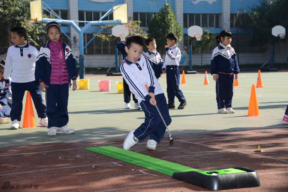 冯珊珊青少年工作室的活动中，孩子们围成一圈，快乐地尝试用特制球杆击打大型彩色高尔夫球。
