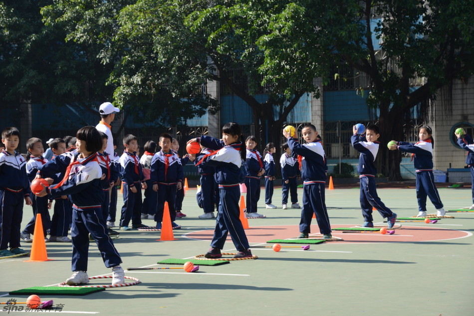 小学体育馆内，孩子们分组进行趣味高尔夫挑战赛，在欢声笑语中感受团队协作与体育竞技的魅力。