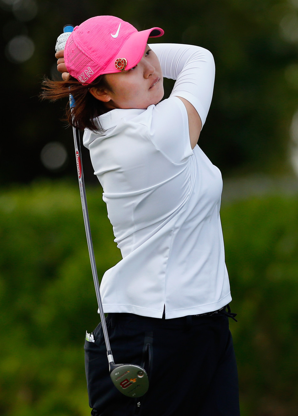 球员在沙坑中奋力一击，球杆划起一道沙瀑，小球精准飞向果岭旗杆