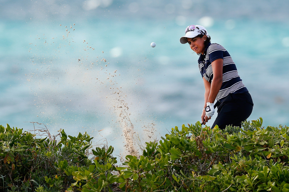 莱克茜·汤普森在全神贯注地推杆，果岭上的草纹清晰可见，决定胜负的一推即将出手