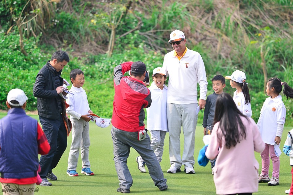教练与选手并肩走在葱郁的球道上，一边行走一边交流，构成一幅和谐的教学画卷